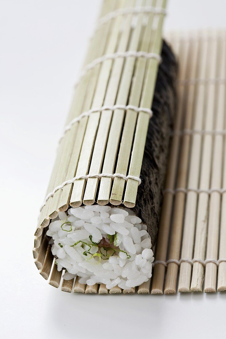 Sushi filled with tuna and negi (Japanese spring onions) being rolled