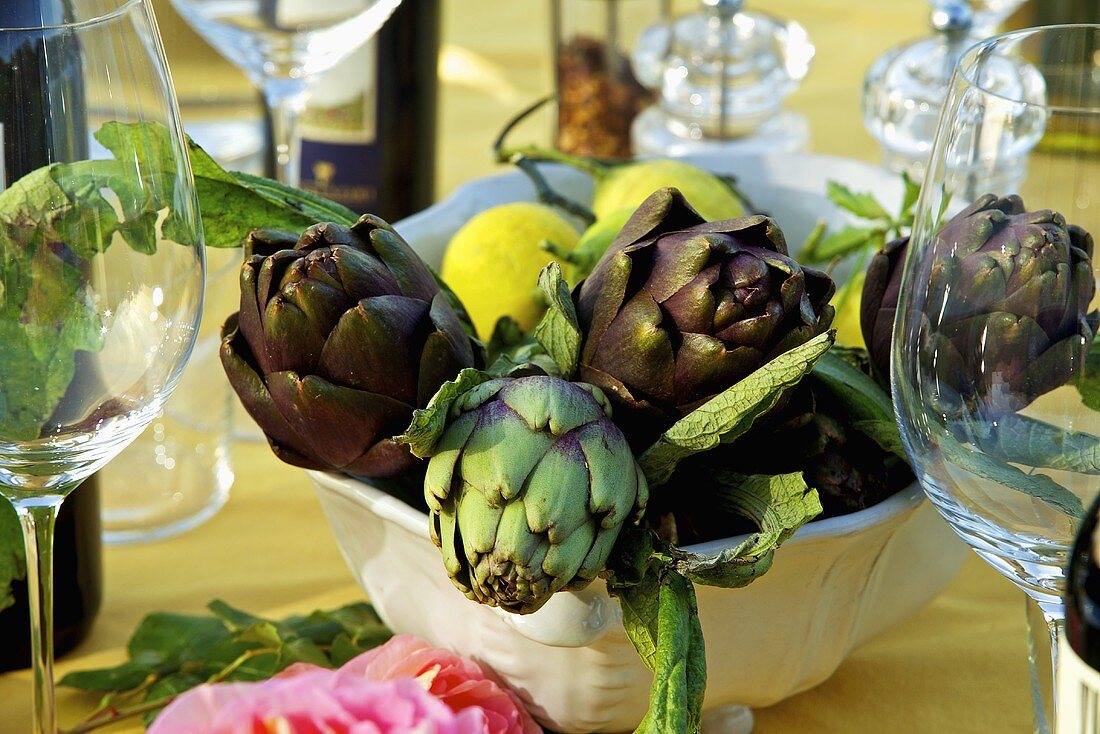 An arrangement of artichokes and lemons in a bowl