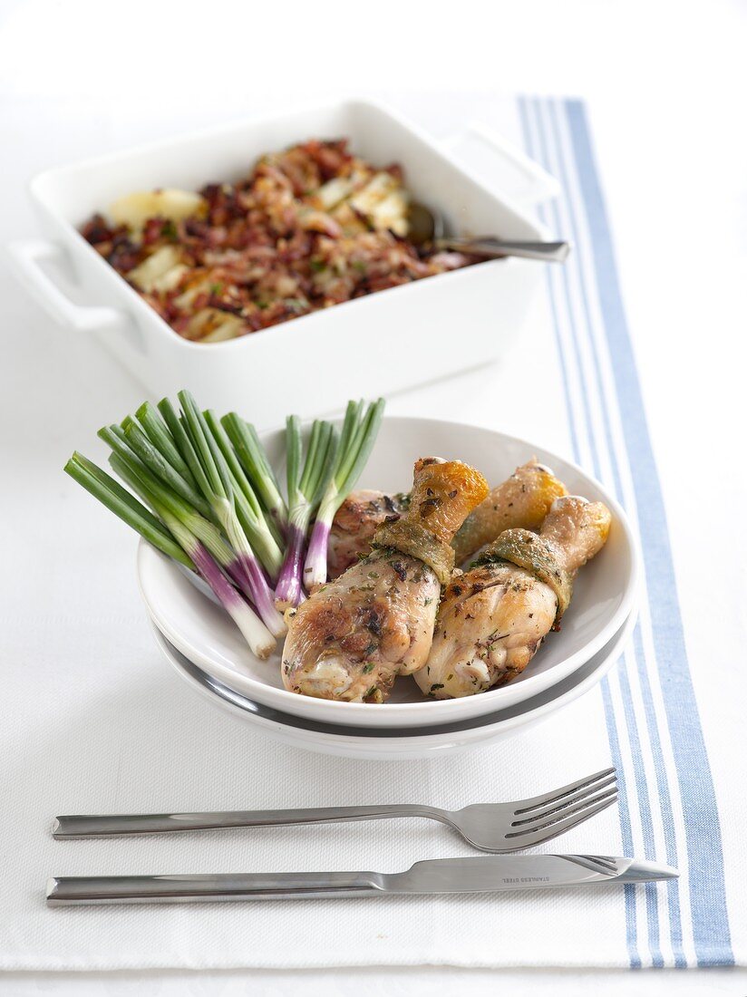 Roasted chicken legs with spring onions and fried potatoes