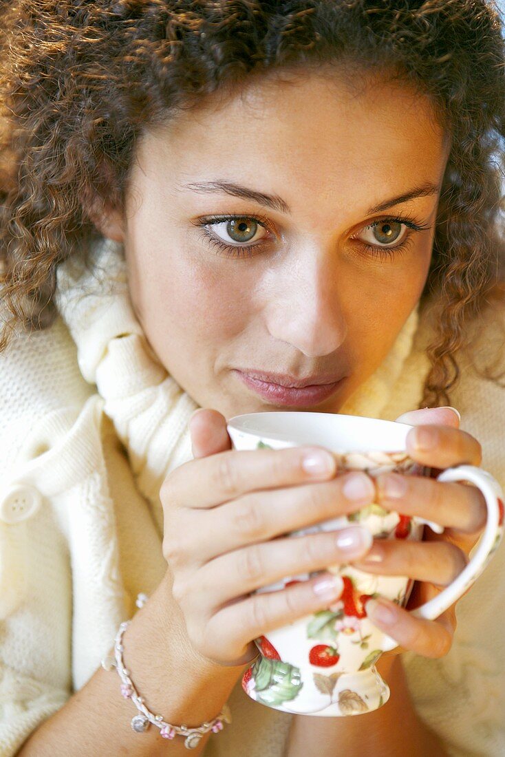 Junge Frau trinkt heißen Tee