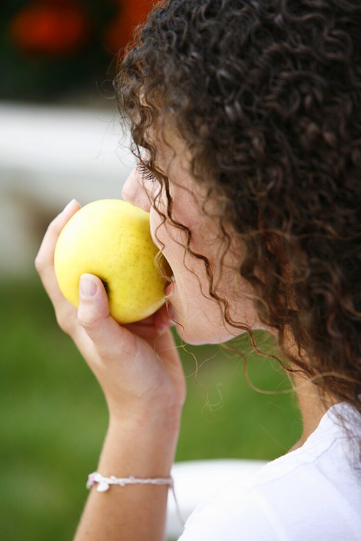 A young woman eating an apple