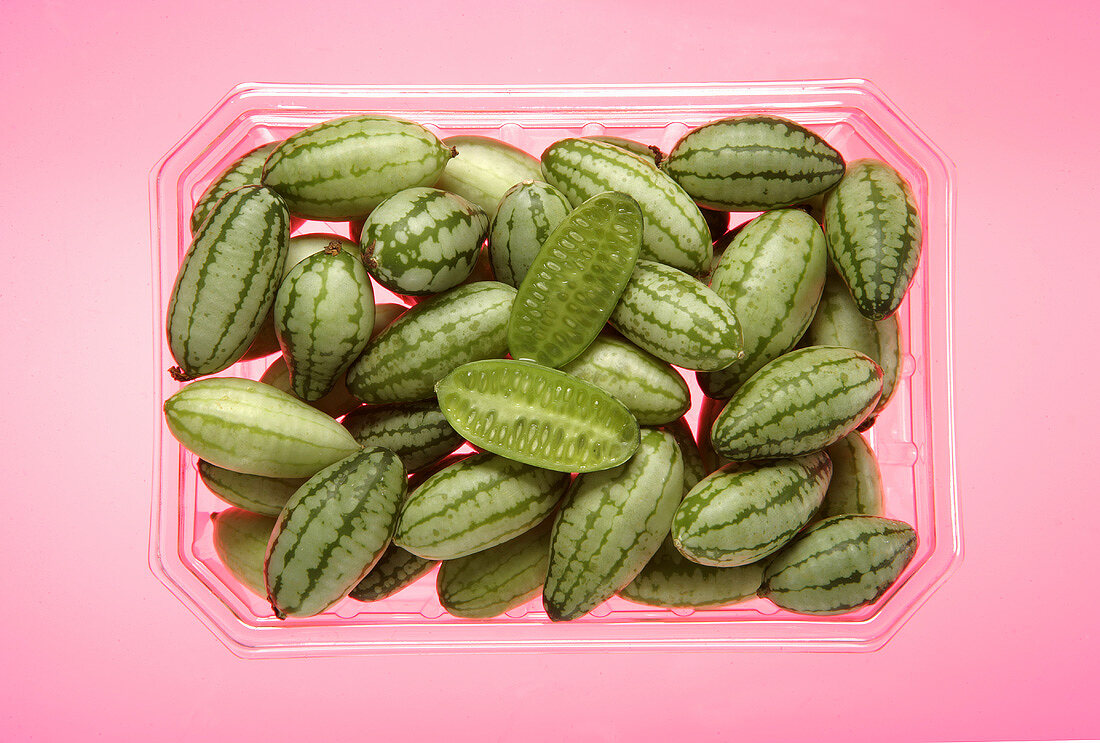 Baby cucumbers in a plastic container