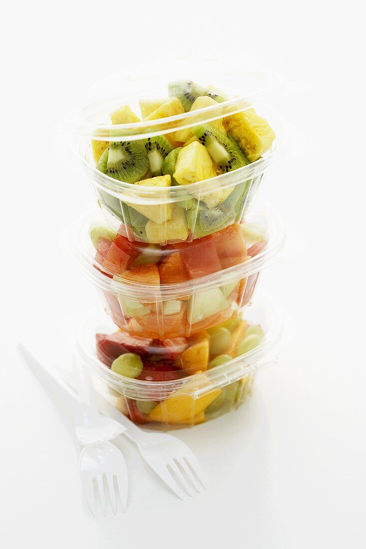 Mixed fruit salad in three plastic containers