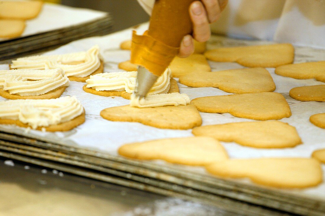 Piping cream onto biscuits