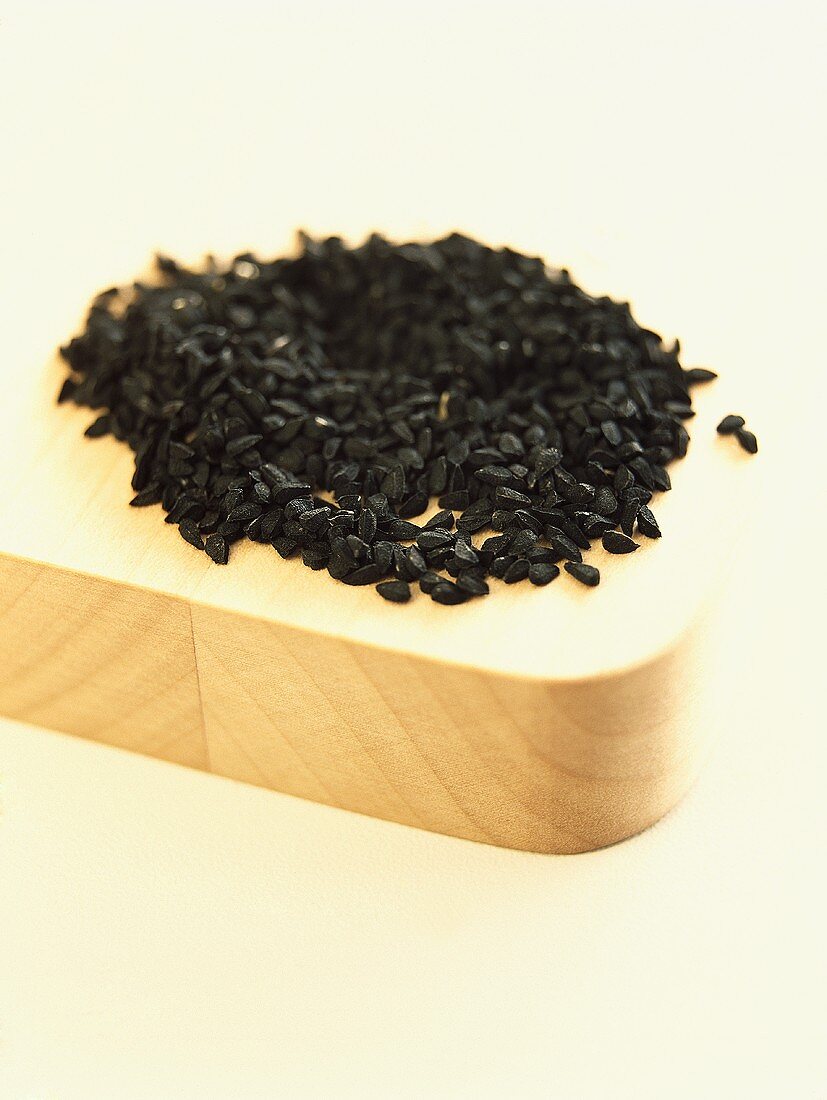 Black sesame seeds on a wooden board