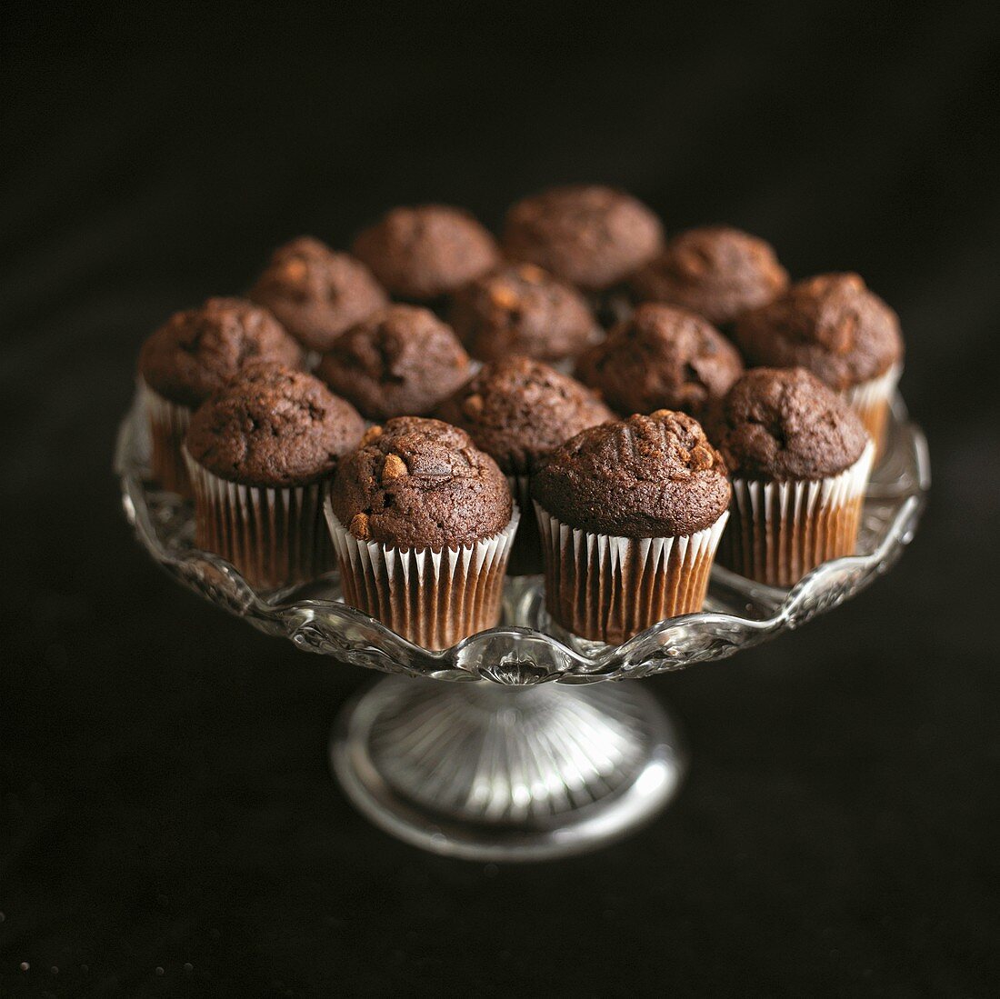 Mini chocolate muffins on a pedestal cake stand