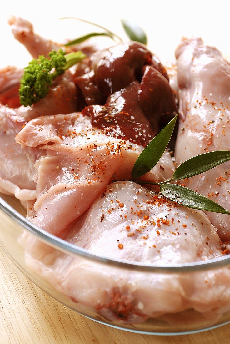 Seasoned rabbit meat in a glass bowl