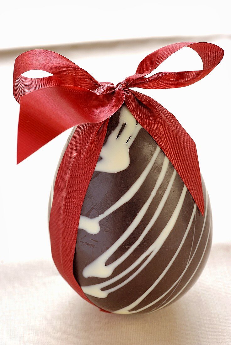 A chocolate Easter egg with a red bow