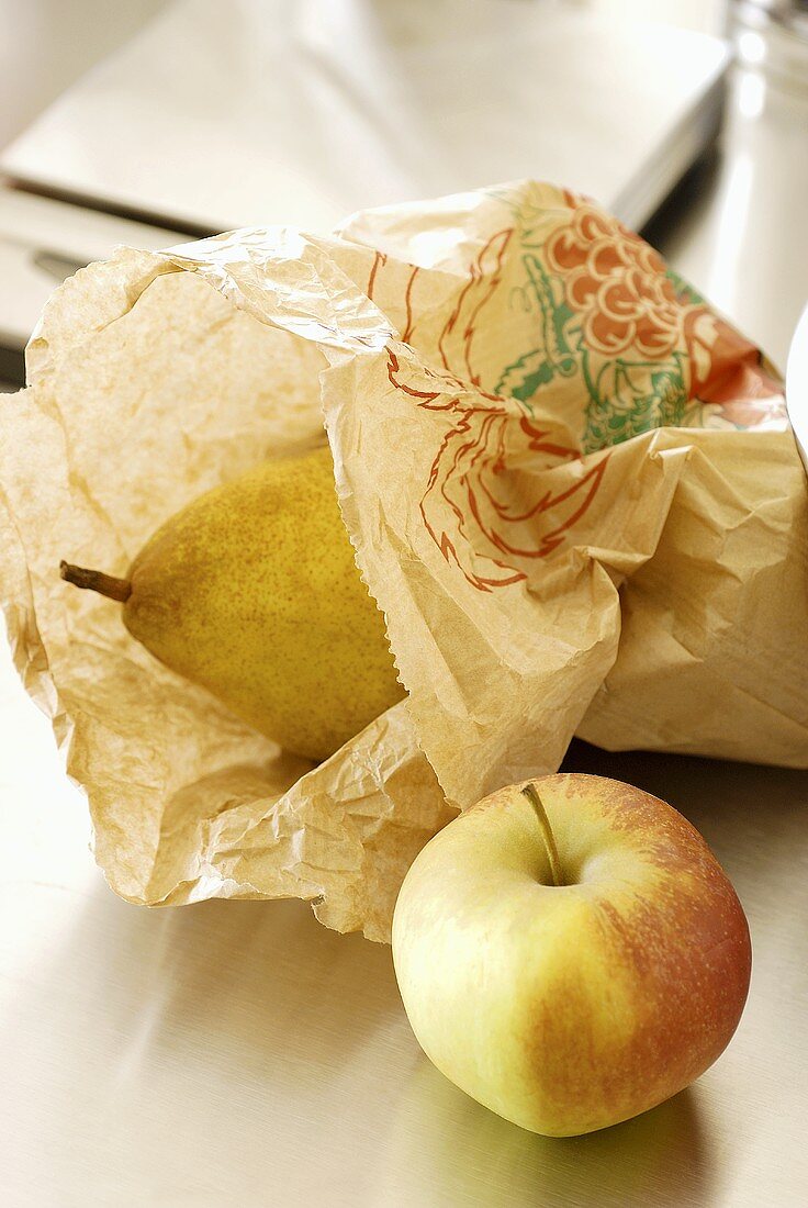An apple and a pear in a paper bag