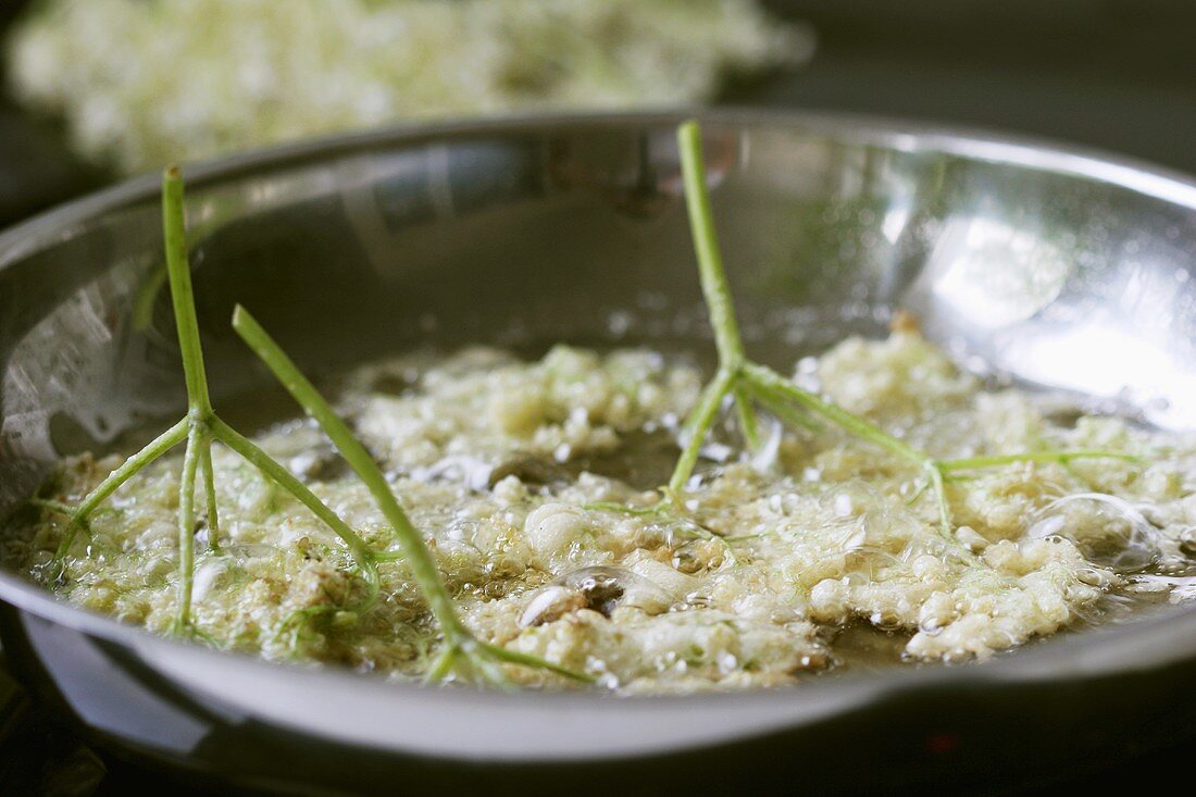 Frying elderflower fritters in fat