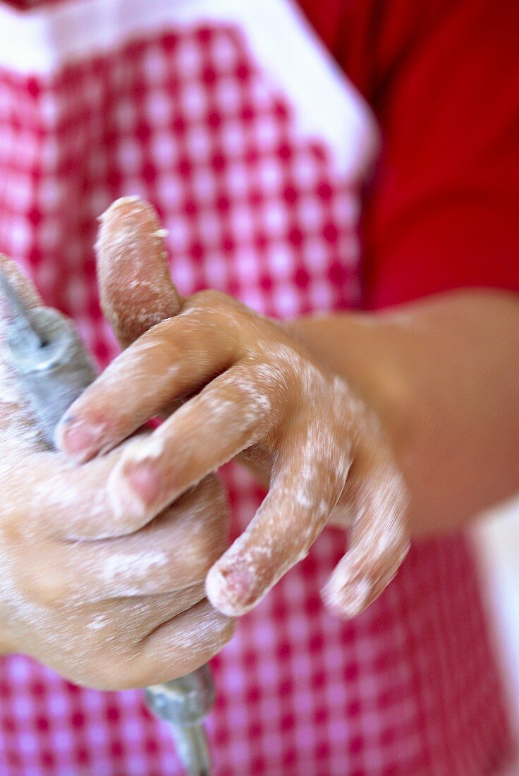Child's hands using a whisk