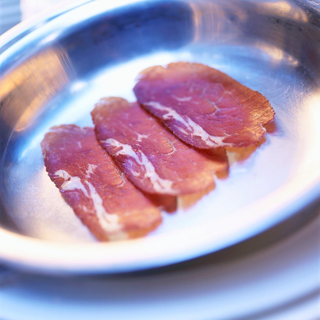 Three slices of French salami in a dish