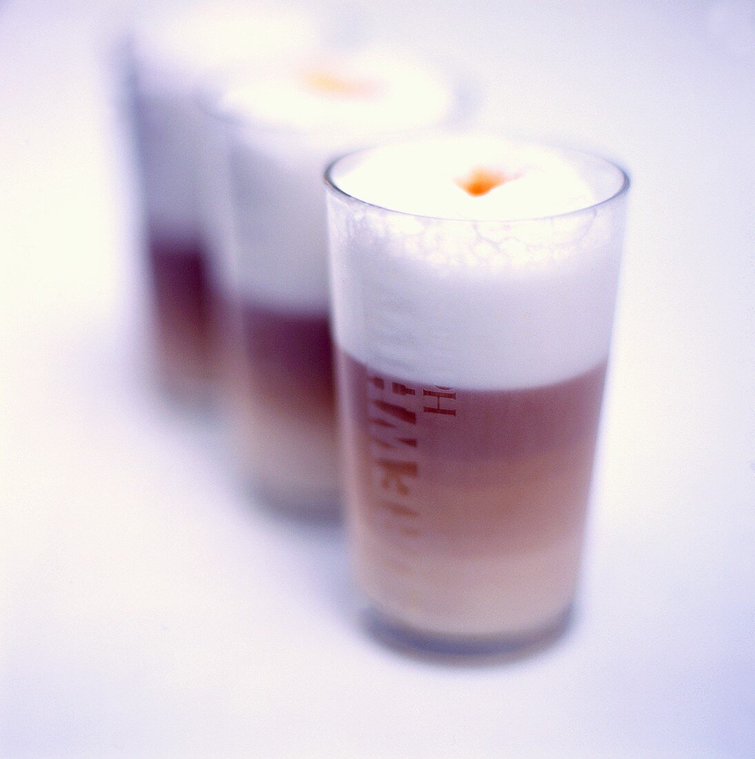 Milky coffee in three glasses