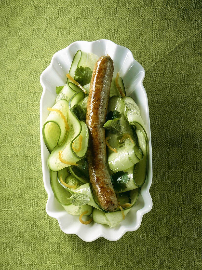A sausage on cucumber salad