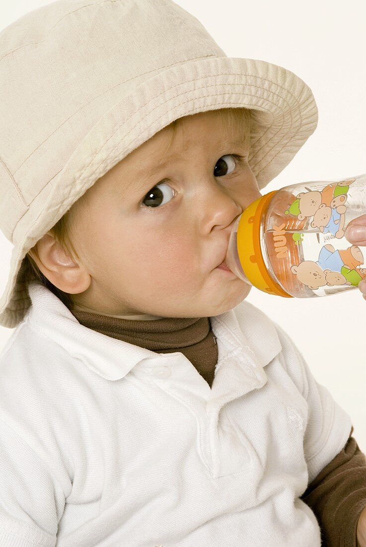 Small boy drinking out of a bottle