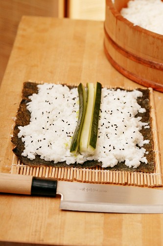 Preparing maki-sushi with cucumber
