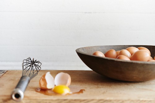 Farm Fresh Eggs in wooden bowl, one cracked open