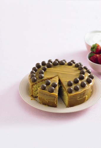 A mud cake topped with caramel and chocolate pearls