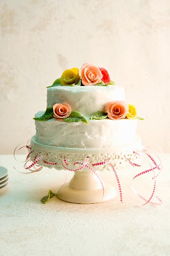 A two-tier wedding cake decorated with marzipan roses