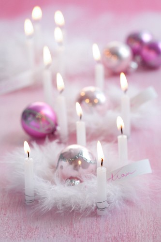Pink Christmas arrangements of candles, baubles & feathers