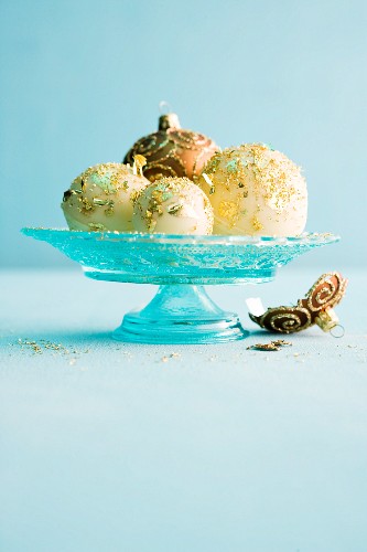 Homemade chocolate baubles decorated with gold leaf as snacks