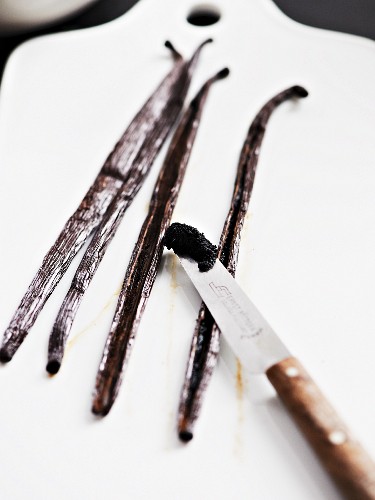 Vanilla pods and scrapped out seeds on a knife
