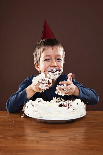 Boy eating a piece of chocolate cake – License Images – 934666 ❘ StockFood