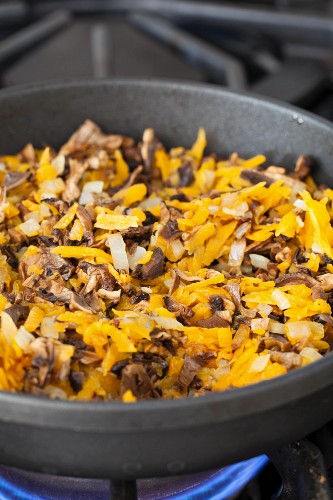 Carrots, onions and soaked mushrooms in a pan for buckwheat hash