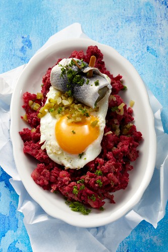Labskaus (traditional dish from Northern Germany featuring salted meat, potatoes and onions) here made with corned beef with a fried egg and roll mop herring