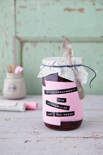 Damson compote in a jar labelled with black embossed band