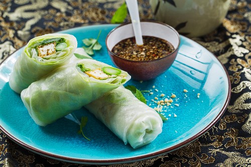 Vegan rice paper rolls with tofu, green asparagus and fresh herbs