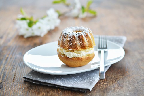 A mini Bundt cake with cream and icing sugar