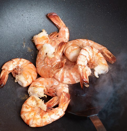 King prawns being fried in a wok