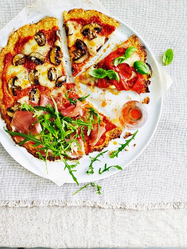 Glutenfreie Blumenkohl-Pizza mit Prosciutto, Champignons und Rucola