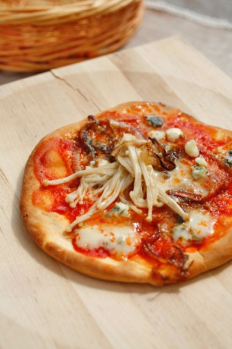 Pizza mit Blauschimmelkäse, Zwiebeln und Enoki-Pilzen