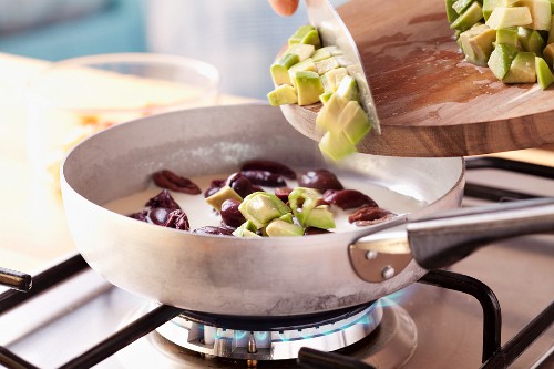 Gemüseomelett zubereiten: Schwarze Oliven und Avocado in die Sahnesauce geben