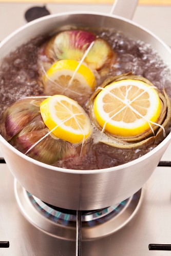 Cooking artichokes in salted water with lemon slices