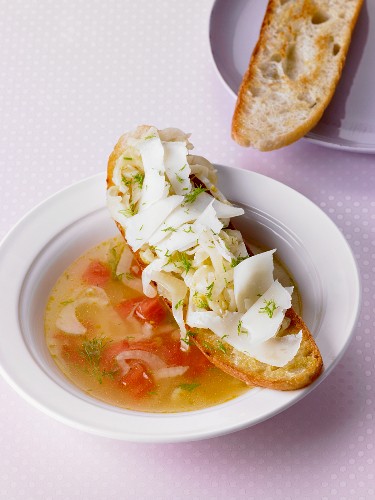 Fennel soup with tomatoes served with crostini topped with fennel and manchego cheese