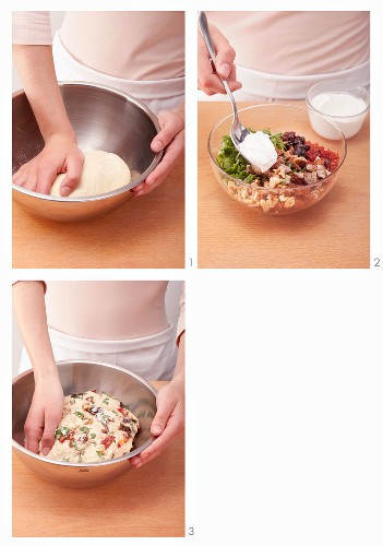 Bread dough being prepared with rocket and dried fruit