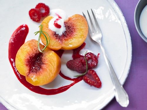 A poached peach with raspberry purée and vanilla yoghurt