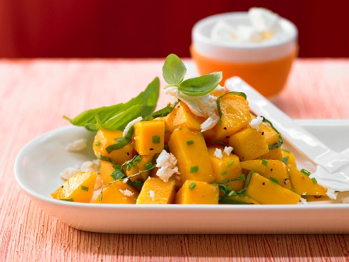 A spicy mango salad with sheep's cheese, basil and chives