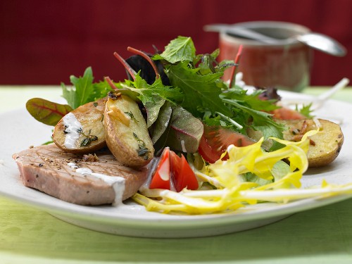 Gegrillter Thunfisch mit gerösteten Kartoffeln, dazu Blattsalat mit Pfefferdressing