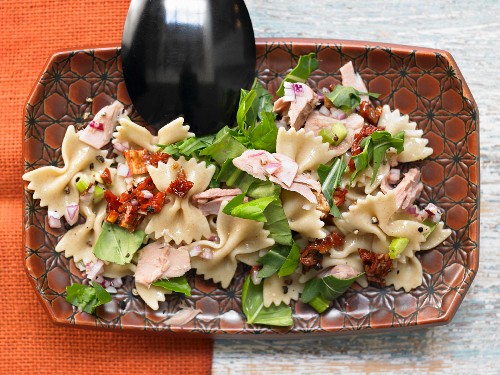 Pasta salad with tuna, dried tomatoes and rocket in a citrus vinaigrette