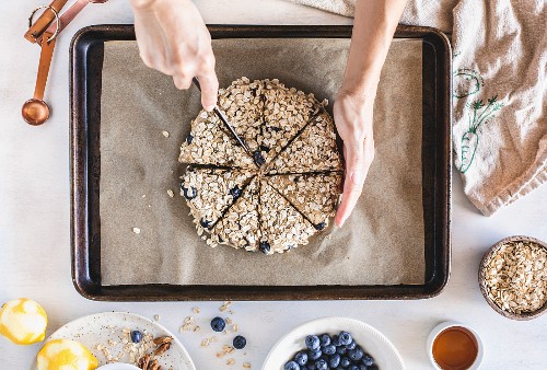 A woman is slicing the dough for spelt flour scones before they go to the oven