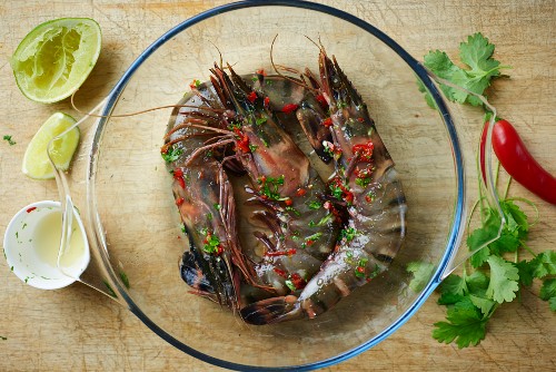 Raw tiger prawns being marinated in lime, honey, chilli and coriander