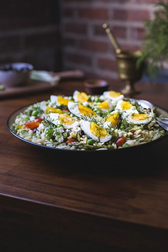 A large bowl of Mediterranean-Style Orzo Salad with Spring Vegetables