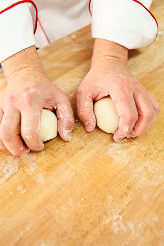 Dough being shaped into round balls