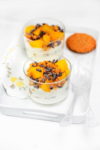 Creamy yoghurt with muesli, canned peaches and chocolate rolls