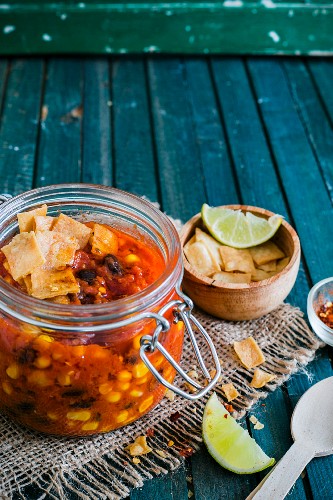 Vegan chilli in a glass jar with tortilla chips
