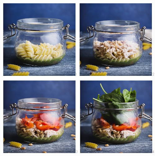 Salad with fusilli, pesto, red pepper, spinach, chicken and parmesan being made